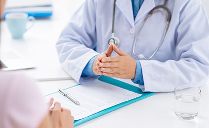 Doctor pressing palms together over patient's chart