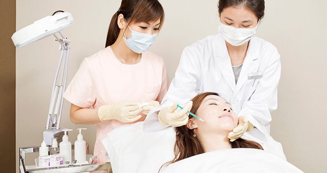 Doctor and nurse performing a medical aesthetics injection